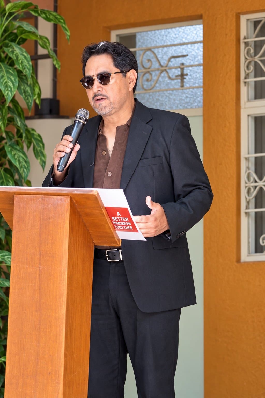 Eduardo Ramos speaking at a podium with a microphone